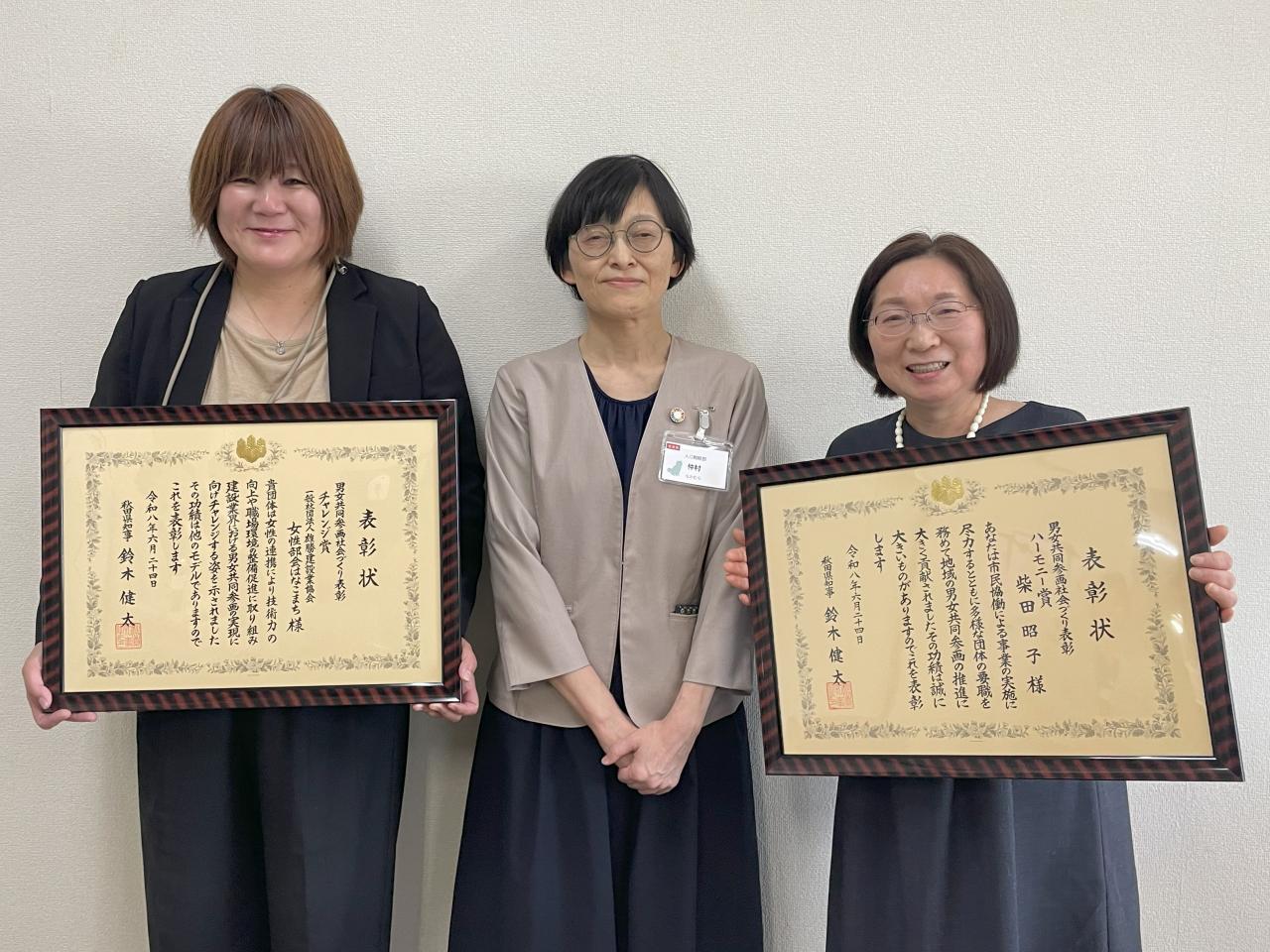 ハーモニー賞受賞者の柴田昭子氏、仲村秋田県人口戦略部長、ハーモニー賞受賞のはなこまち代表千葉愛氏の表彰式での写真